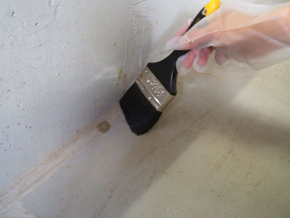 壁際の施工面を刷毛で清掃する施工手順
